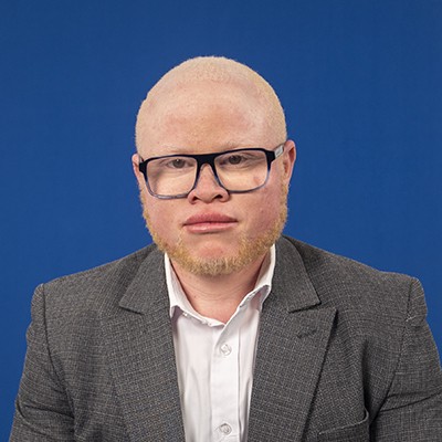 Alan H Onyangois headshot against blue background