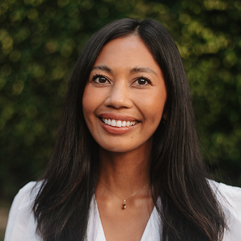 A woman with long dark hair, smiling at the camera.