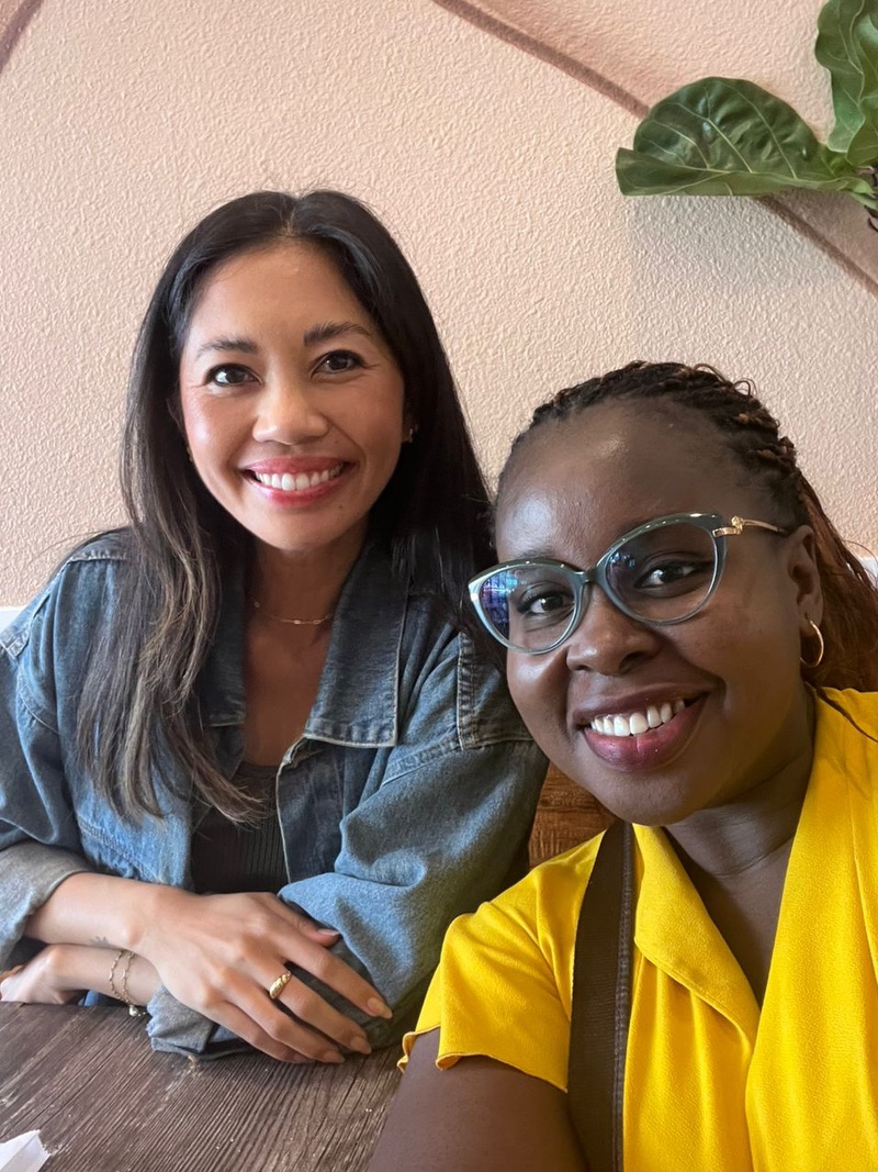 Two women smile at the camera while taking a selfie. 
