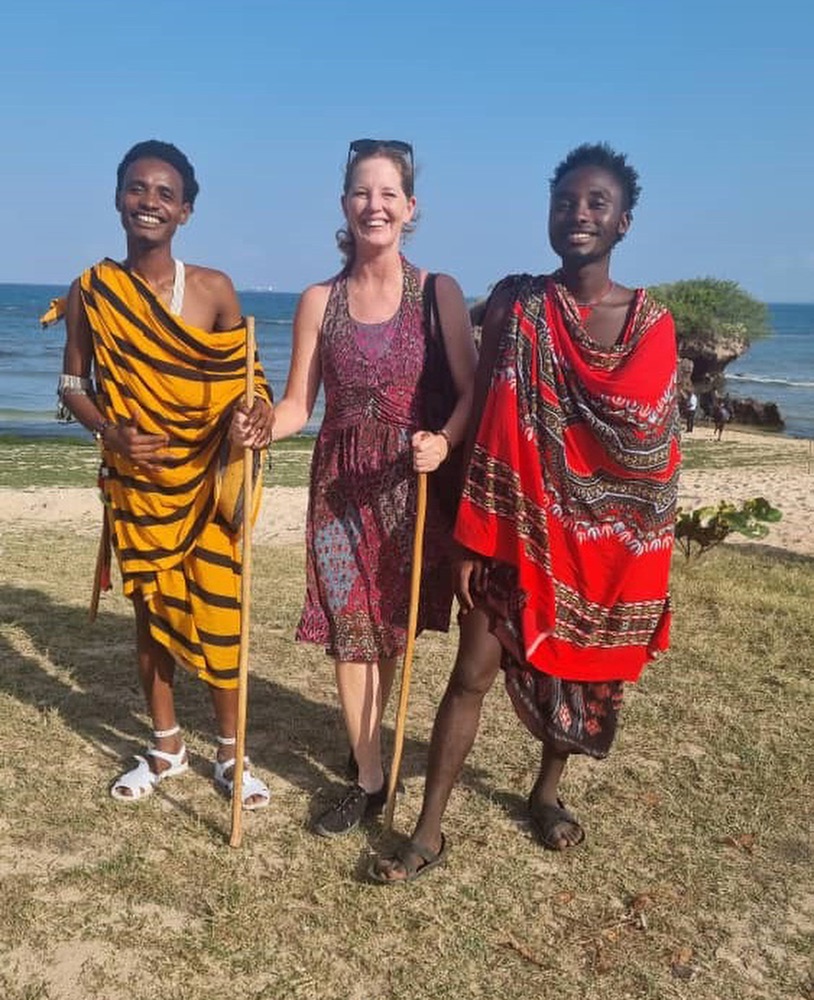 An American woman posing for a photo with two Maasai men.