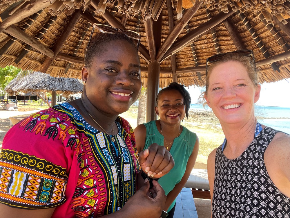 An American woman posing for a group photo with two Tanzanian women.