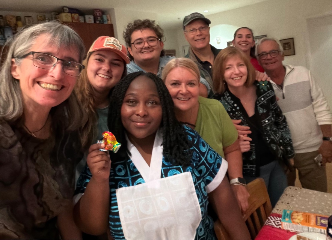 A group of nine people posing for a photo, smiling at the camera.